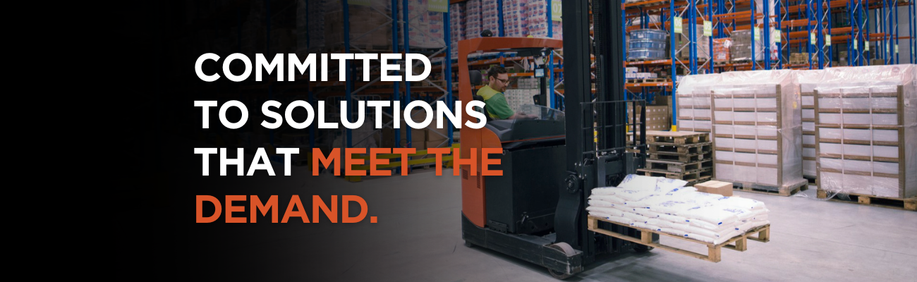 Forklift in DC image with caption committed to solutions that meet the demand. Published by Carney Battery Handling